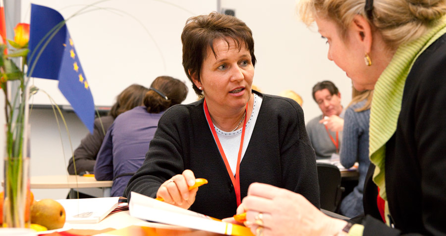 Seminaratmosphäre: zwei Frauen unterhalten sich am Tisch